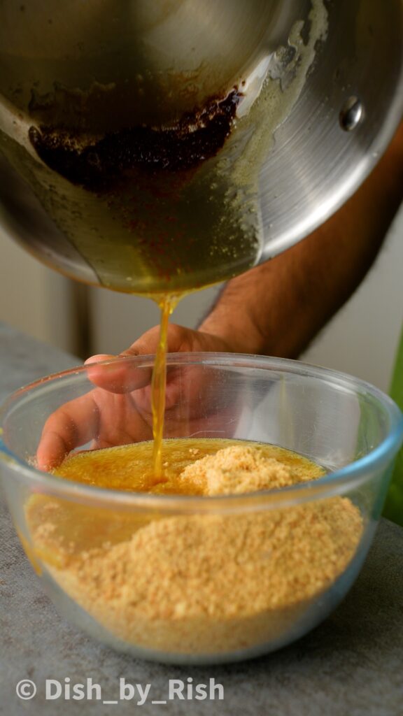 pouring brown butter into biscuit and pistachio mixture
