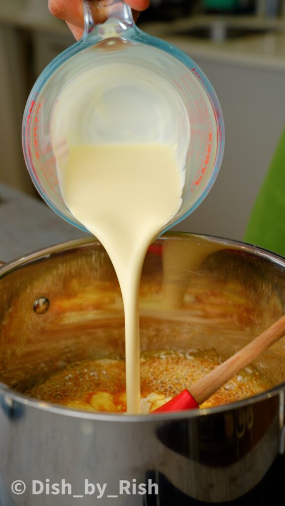 pouring cream into caramel in saucepan