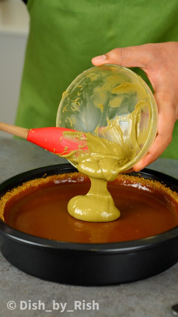pouring pistachio cream over the caramel