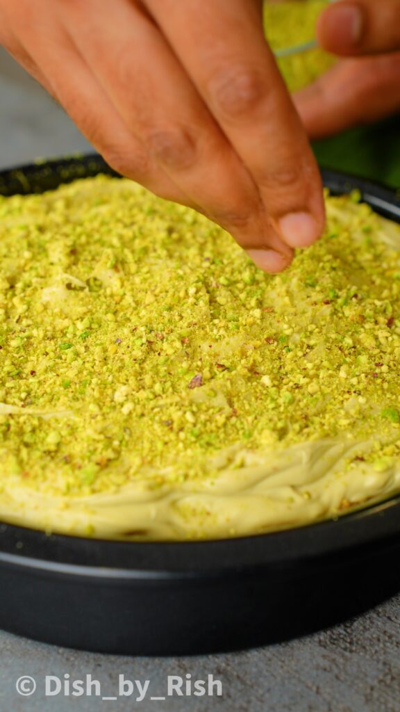 topping the pistachio whipped cream with ground pistachios