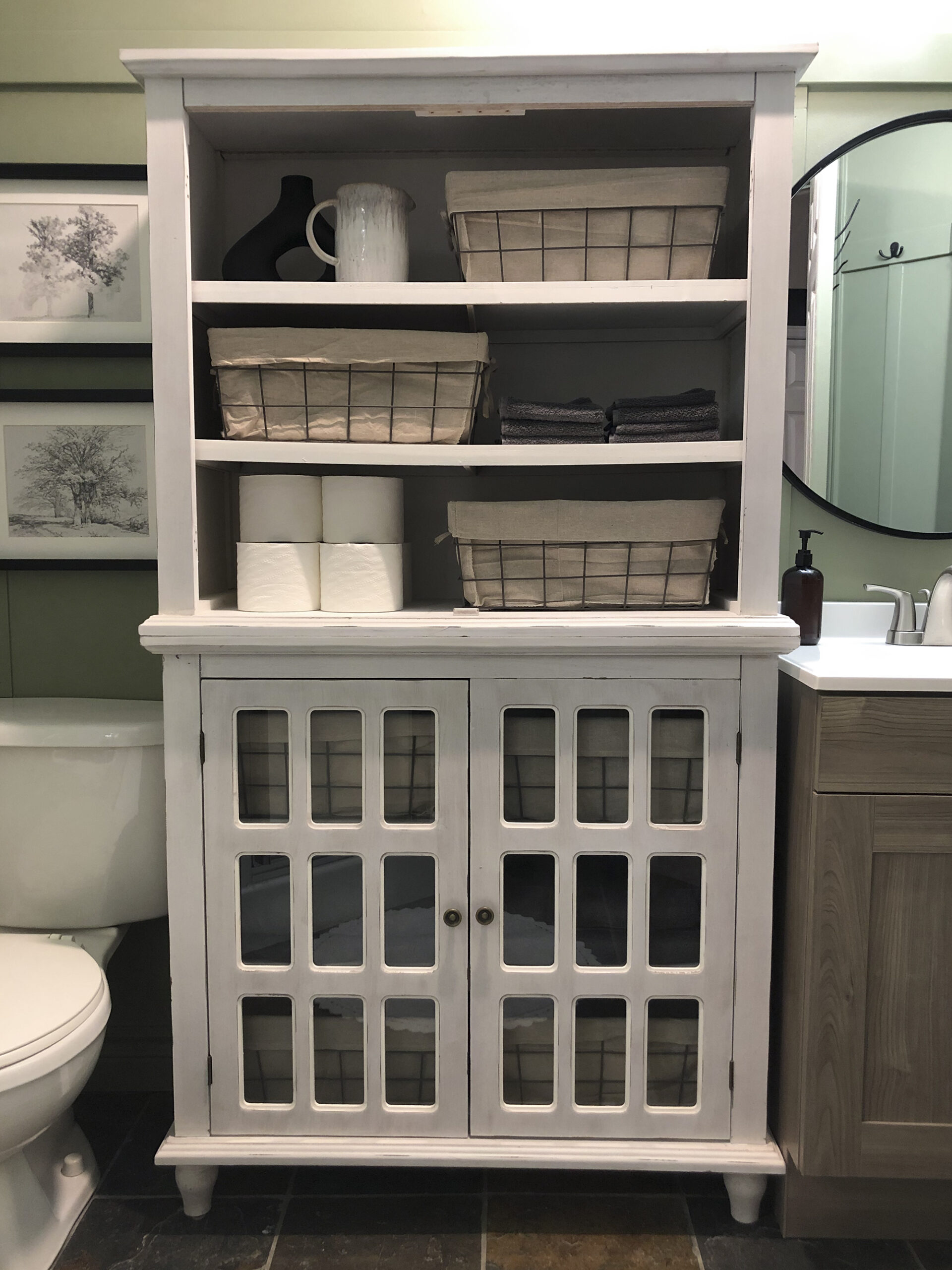 bathroom cabinet with baskets and stacked toilet paper rolls