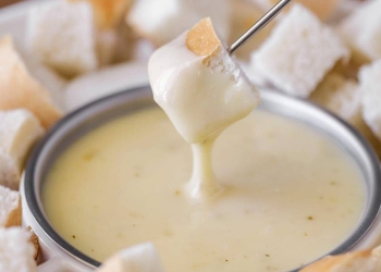 Dipping cubed bread into cheese fondue.