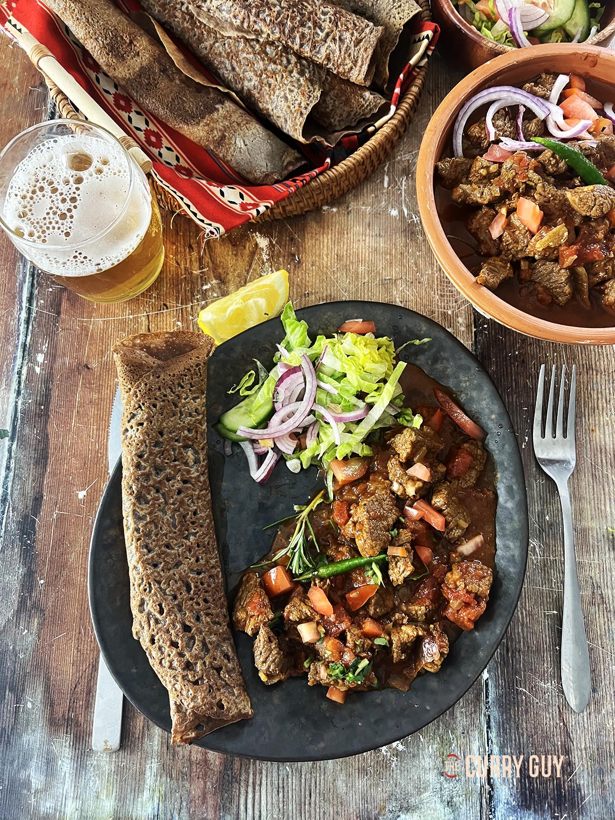 Beef tibs served with injera bread at the table.